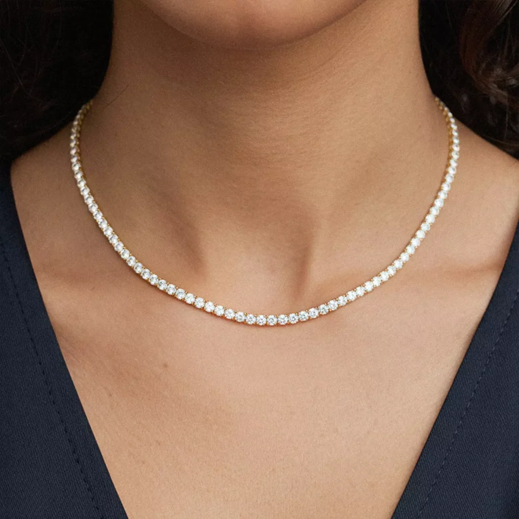 A close-up of a woman's neckline to highlight the bestselling tennis necklace from Rare Carat, one of the best places to buy diamond tennis necklaces