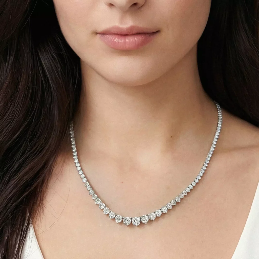 A close-up of a woman's neckline to highlight the natural diamond tennis necklace from Rare Carat